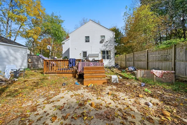 a view of a backyard with wooden fence and a large tree