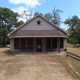 a front view of a house with a yard and potted plants
