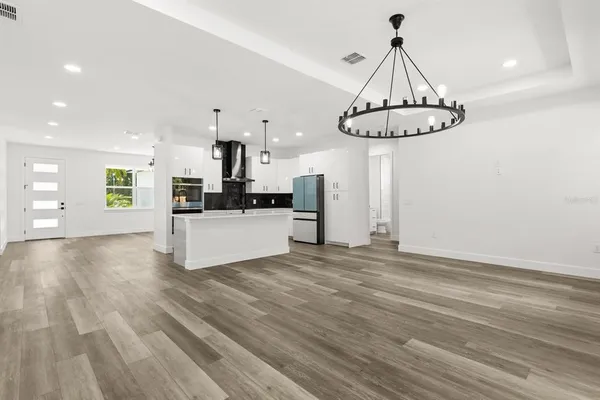 a kitchen with kitchen island granite countertop a stove a sink a center island and wooden floor