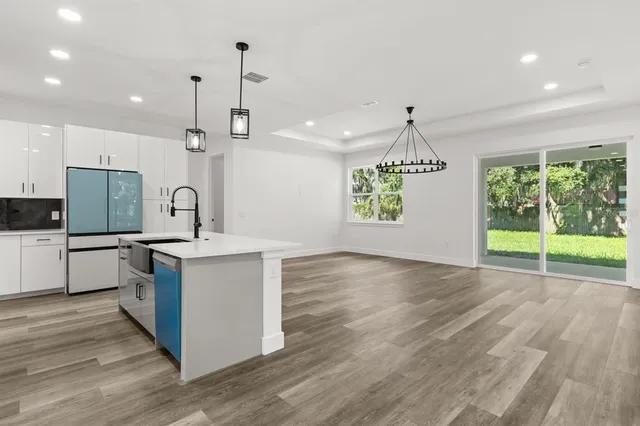 a kitchen with a sink window and wooden floor