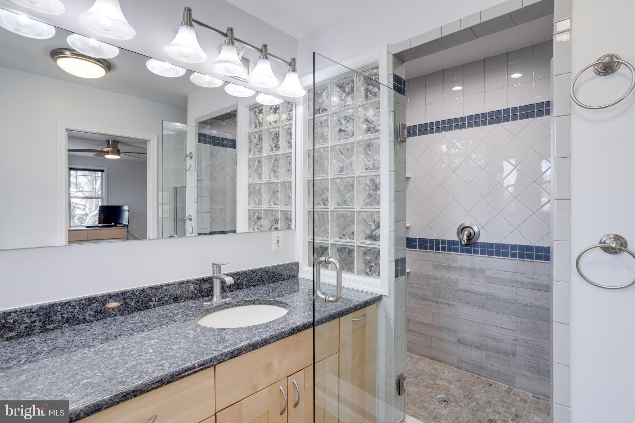 521 Creek Crossing Road Northeast Vienna, VA 22180 - Photo 31 of 63 a bathroom with a granite countertop sink a mirror and a shower