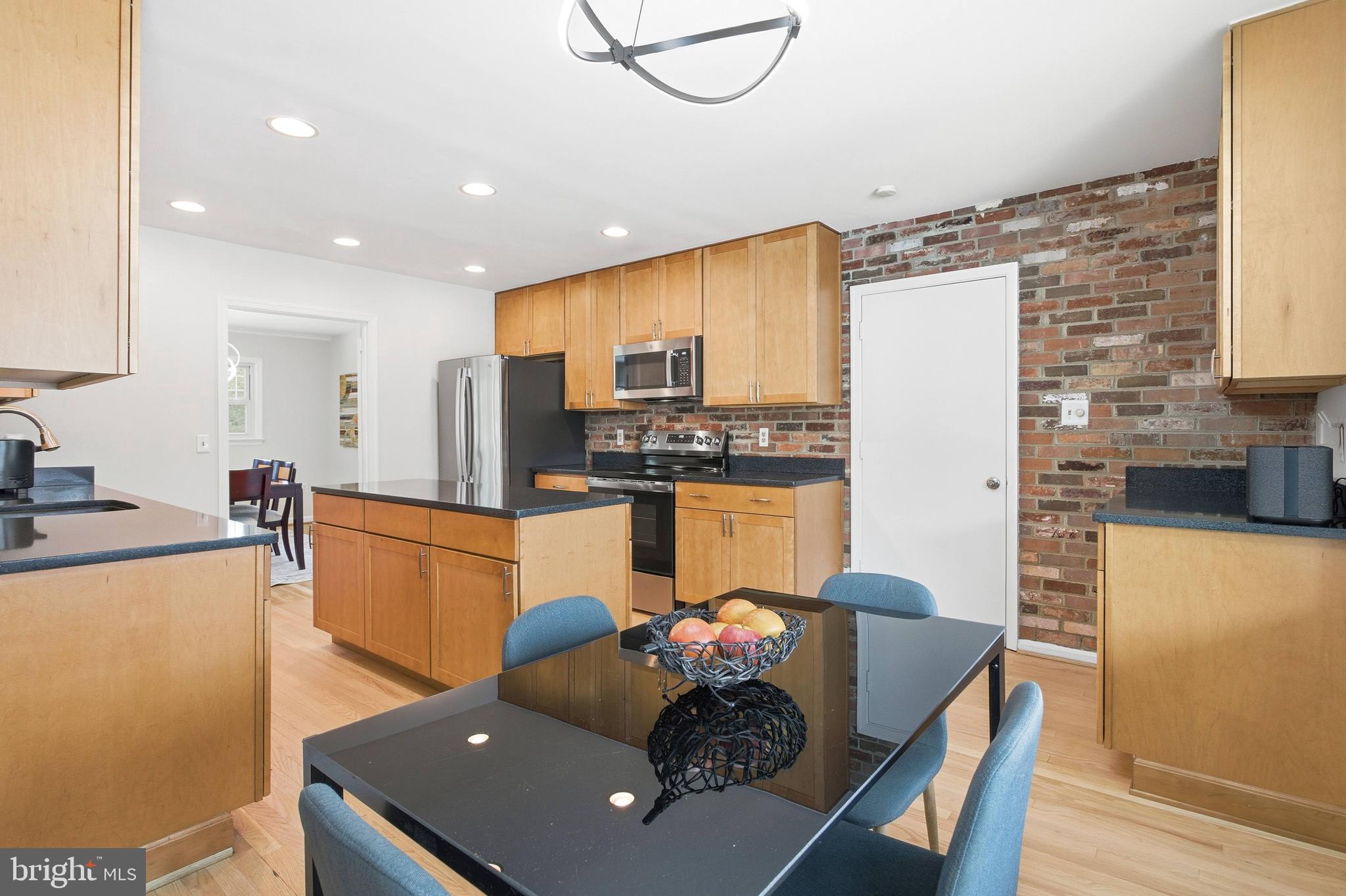 521 Creek Crossing Road Northeast Vienna, VA 22180 - Photo 9 of 63 a kitchen with stainless steel appliances granite countertop a sink refrigerator dining table and chairs