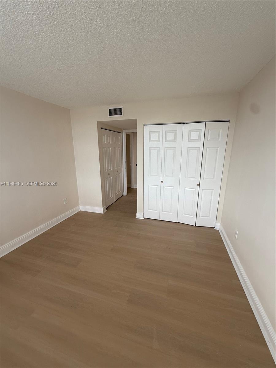 484 Northwest 165th St Road, Unit A512 Miami, FL 33169 - Photo 14 of 16 a view of an empty room and wooden floor