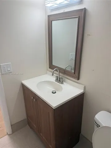 a bathroom with a sink vanity and a toilet