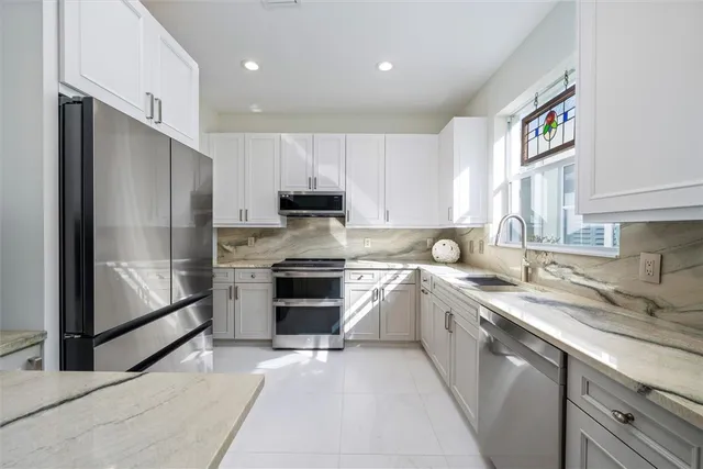 a kitchen with appliances a sink and cabinets