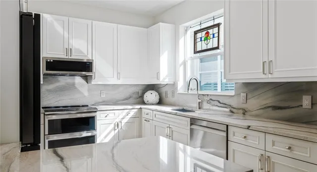 a kitchen with white cabinets and a sink