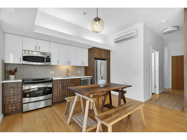 a kitchen with stainless steel appliances kitchen island granite countertop a stove a sink a refrigerator and a microwave