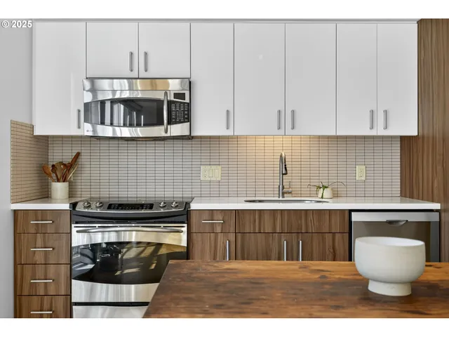 a kitchen with stainless steel appliances granite countertop a stove a sink and a microwave