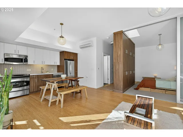 a living room with stainless steel appliances kitchen island granite countertop a dining table chairs and granite counter tops