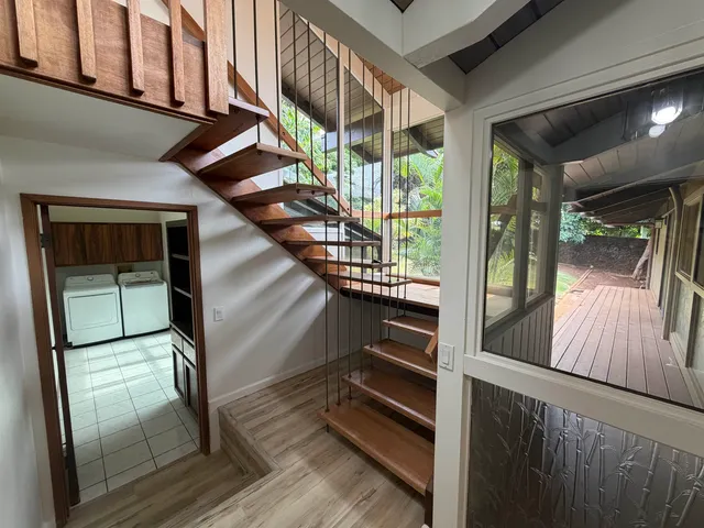a view of a hallway with wooden floor and glass door