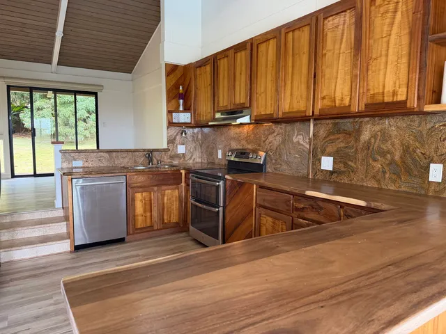 a kitchen with stainless steel appliances granite countertop a stove a sink dishwasher and a microwave oven with cabinets