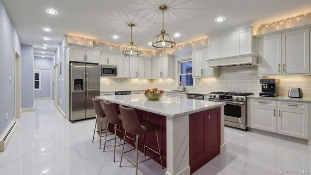 a kitchen with kitchen island granite countertop a sink a center island and stainless steel appliances