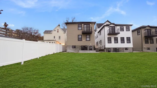 a view of a big house with a big yard and large trees
