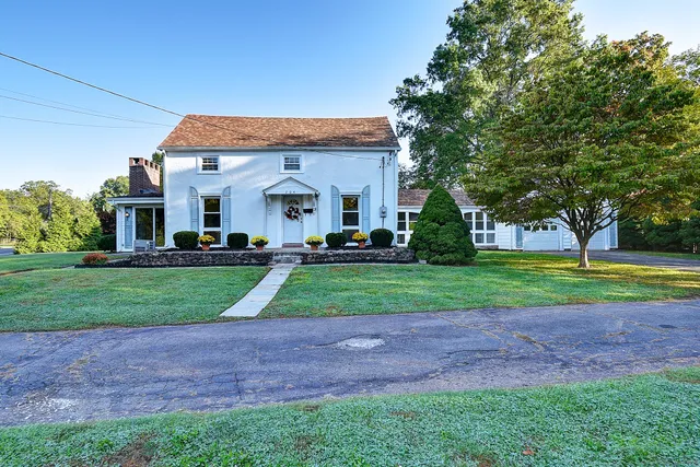 a front view of a house with a yard and trees