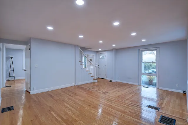 a view of empty room with wooden floor