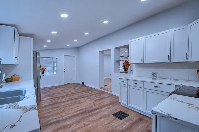 a large kitchen with cabinets and wooden floor