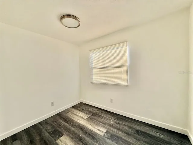a view of a room with wooden floor and window