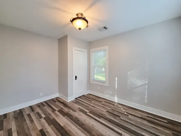 a view of a room with wooden floor and windows