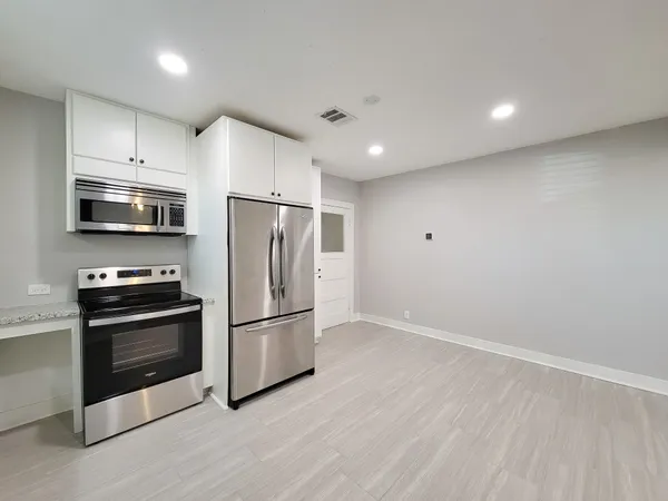 a kitchen with stainless steel appliances granite countertop a refrigerator microwave and stove top oven