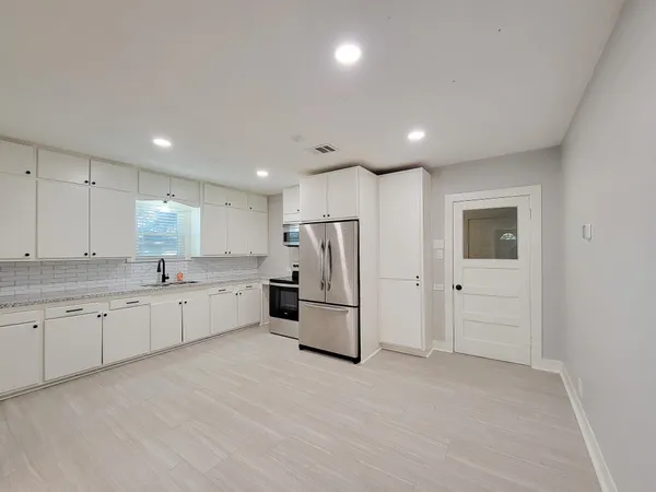 a kitchen with refrigerator and microwave