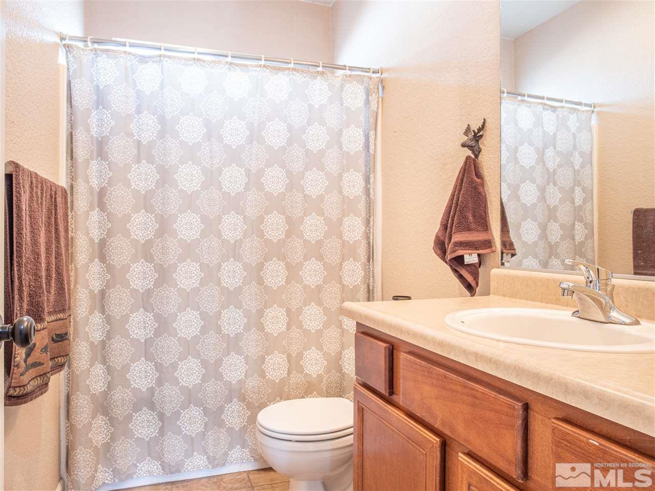 10040 Stonefield Drive Reno, NV 89521 - Photo 14 of 24 a bathroom with a sink a toilet and a mirror