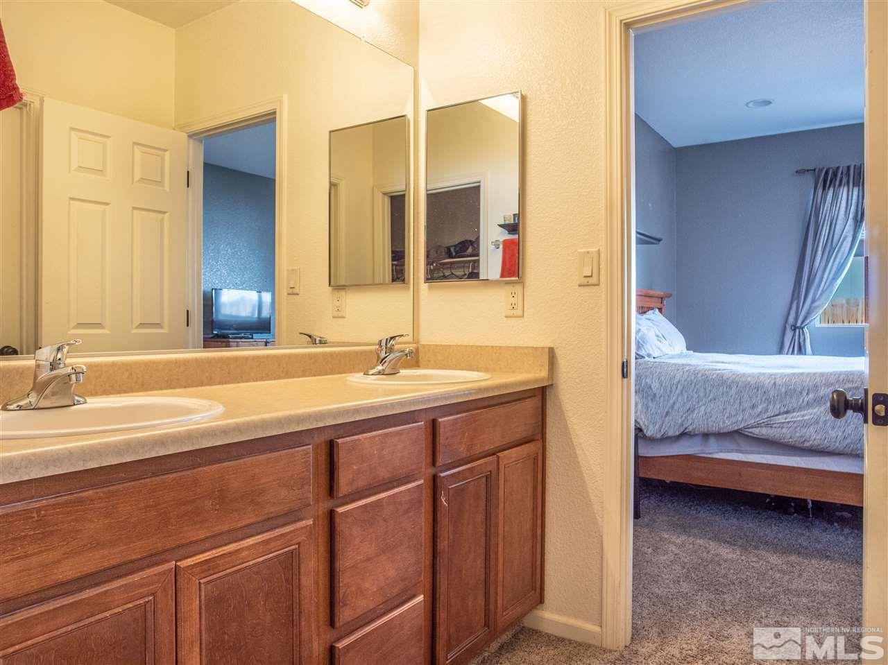 10040 Stonefield Drive Reno, NV 89521 - Photo 16 of 24 a en suite bathroom with a double vanity sink and mirror