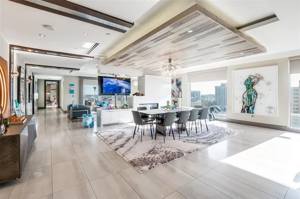 a living room with furniture a dining table and a chandelier