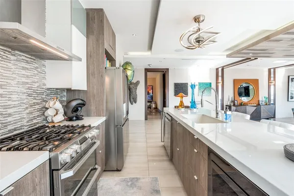a living room with furniture kitchen view and a chandelier