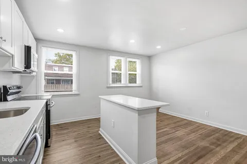 a kitchen with sink cabinets and wooden floor