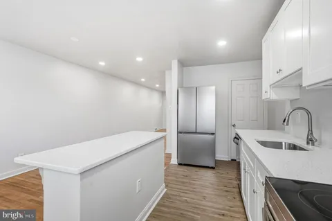 a kitchen with a sink a refrigerator and cabinets