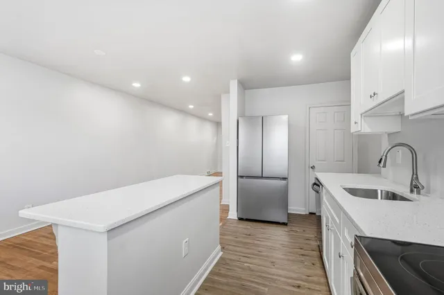 a kitchen with a sink a refrigerator and cabinets