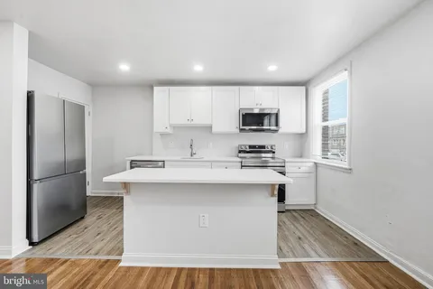 a kitchen with kitchen island a sink stainless steel appliances and cabinets