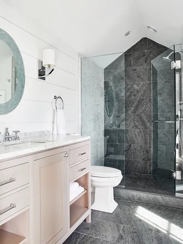 a bathroom with a granite countertop sink toilet a mirror and shower
