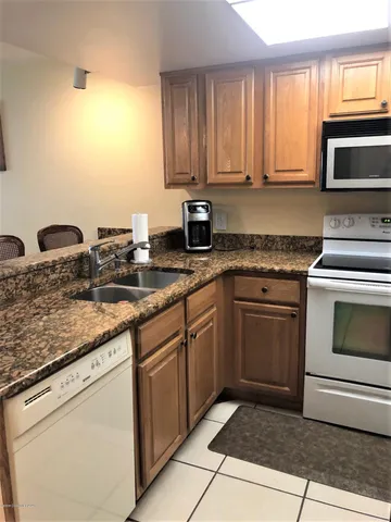 a kitchen with granite countertop a stove sink and cabinets