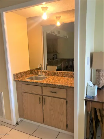 a bathroom with a granite countertop sink and a mirror