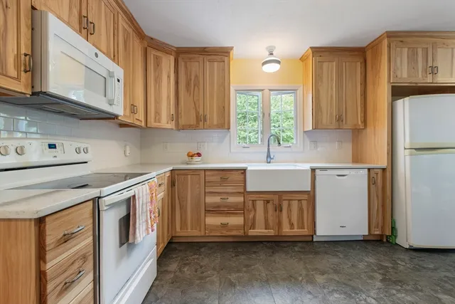 a kitchen with stainless steel appliances granite countertop a sink a stove and a refrigerator