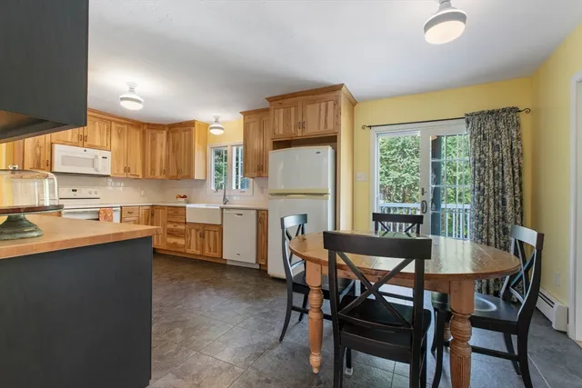 a kitchen with a table chairs sink and cabinets