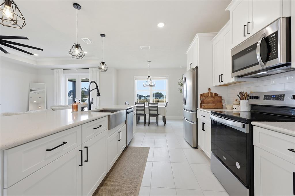 1922 Southwest 244th Way Newberry, FL 32669 - Photo 13 of 31 a kitchen with stainless steel appliances a stove sink and cabinets