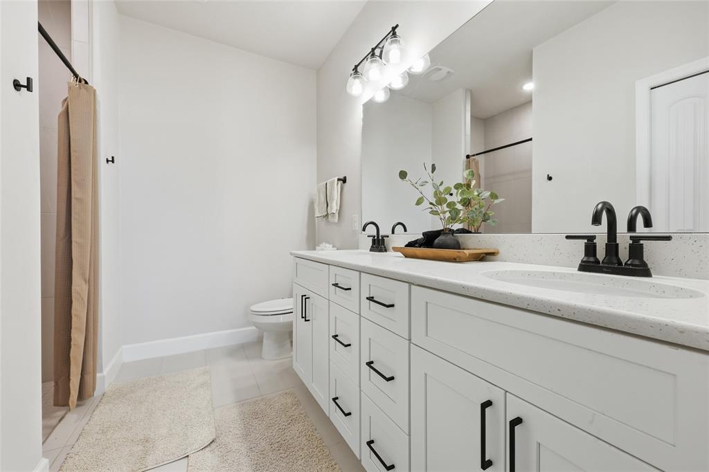 1922 Southwest 244th Way Newberry, FL 32669 - Photo 19 of 31 a bathroom with a double vanity sink toilet and shower