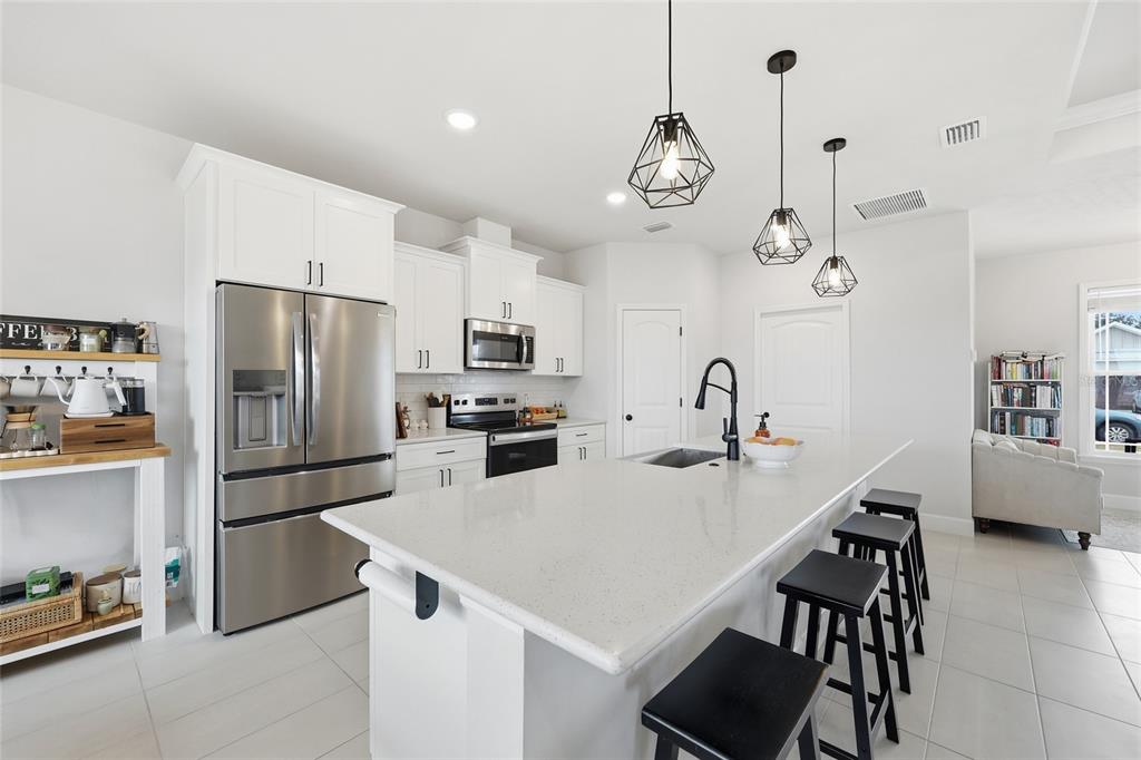 1922 Southwest 244th Way Newberry, FL 32669 - Photo 9 of 31 a kitchen with stainless steel appliances a refrigerator a sink a stove and chairs