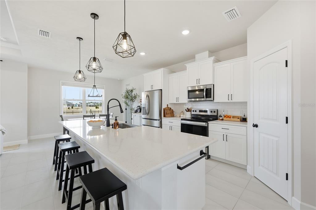 1922 Southwest 244th Way Newberry, FL 32669 - Photo 10 of 31 a kitchen with stainless steel appliances a table chairs and a refrigerator