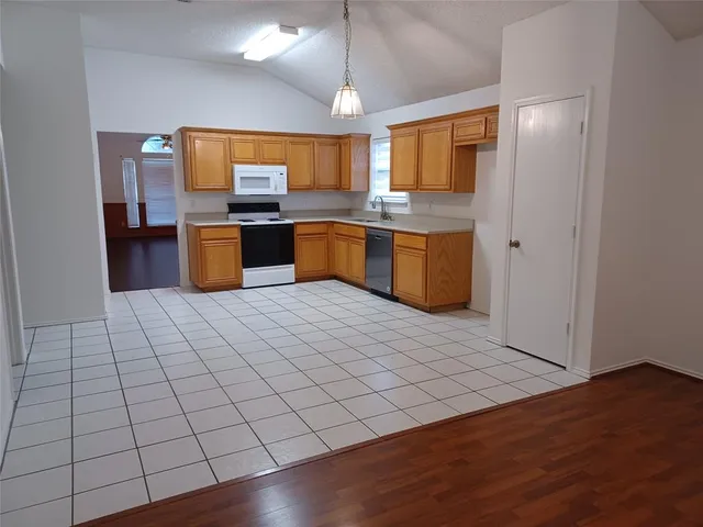 a large kitchen with stainless steel appliances a sink and cabinets