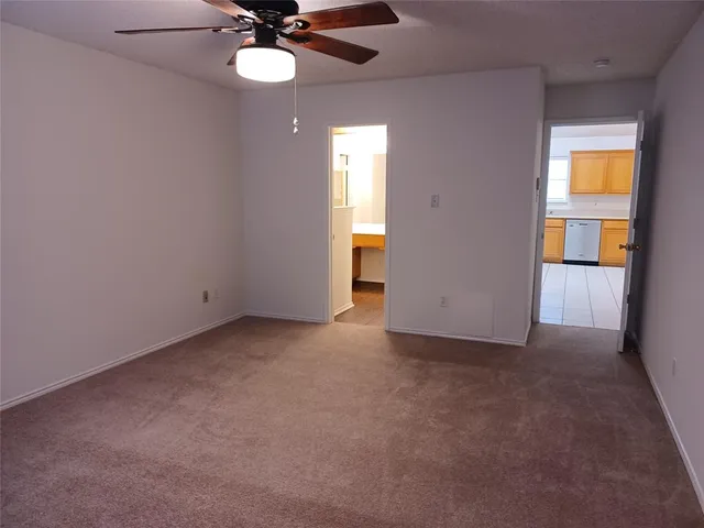 a view of a room with a ceiling fan and a window