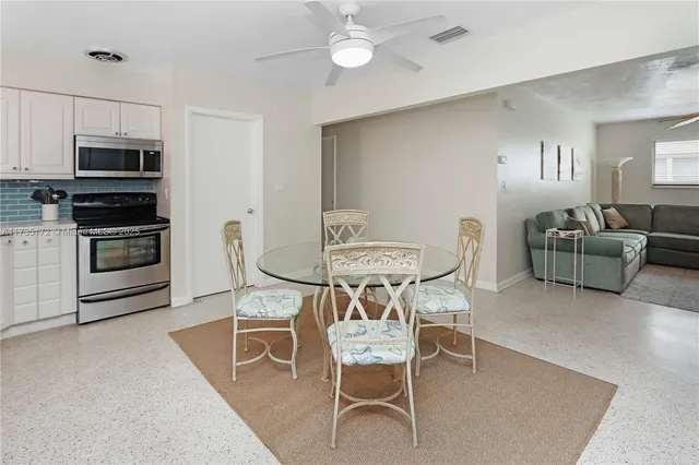 a view of a dining room with furniture and a kitchen