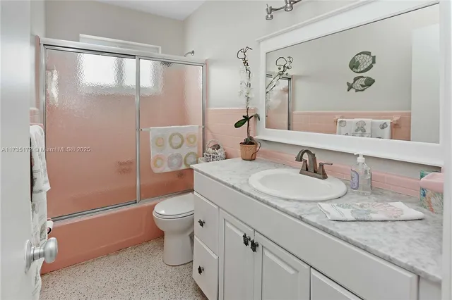 a bathroom with a granite countertop sink a mirror and a toilet