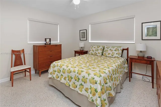 a bedroom with a bed and a lamp on dresser