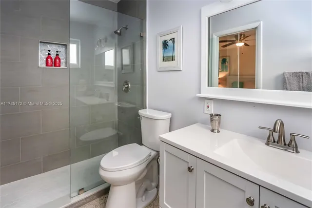 a bathroom with a sink a mirror a toilet and shower