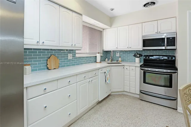 a kitchen with white cabinets and white appliances
