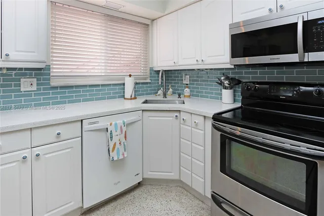 a kitchen with stainless steel appliances a stove microwave and sink