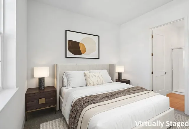 a bedroom with a bed and painting on the wall